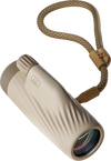 Bushnell A3 monocular in oyster clay color with matching detachable wrist strap on a transparent background.