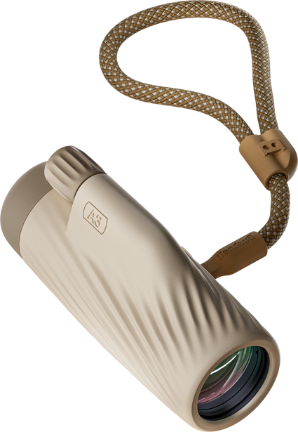 Bushnell A3 monocular in oyster clay color with matching detachable wrist strap on a transparent background.