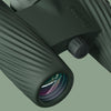 Close-up of a pair of dark green Bushnell A1 binoculars with a brand logo on a light green background
