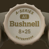 Bushnell A-Series A1 8x25 waterproof lens cap on a brown background