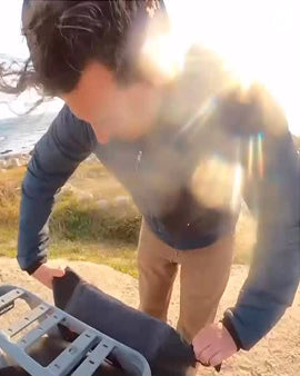 Person outdoors with a bright light source, possibly sun, creating lens flare.