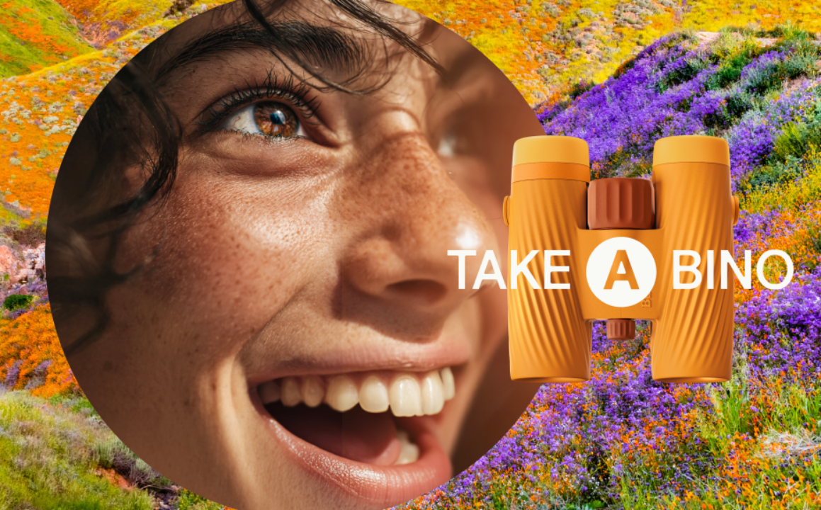Close-up of a person's face with binoculars and 'Take A Bino' text against a colorful floral background.